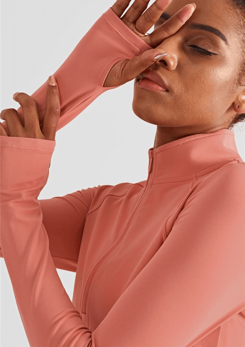 Woman wearing pink long sleeve sports sweatshirt with finger cut-outs